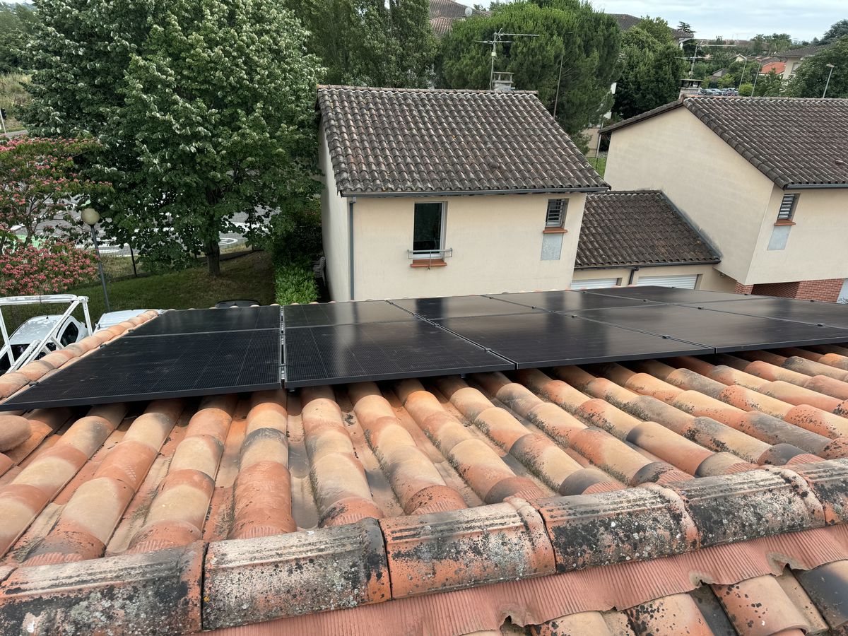 Rangée de panneaux solaires sur une toiture en tuiles à Toulouse