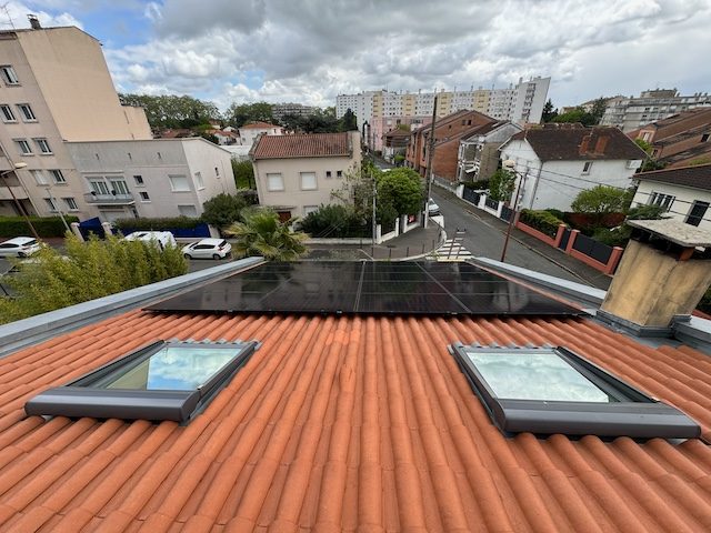 Panneaux solaires sur une toiture en tuiles avec fenêtres de toit
